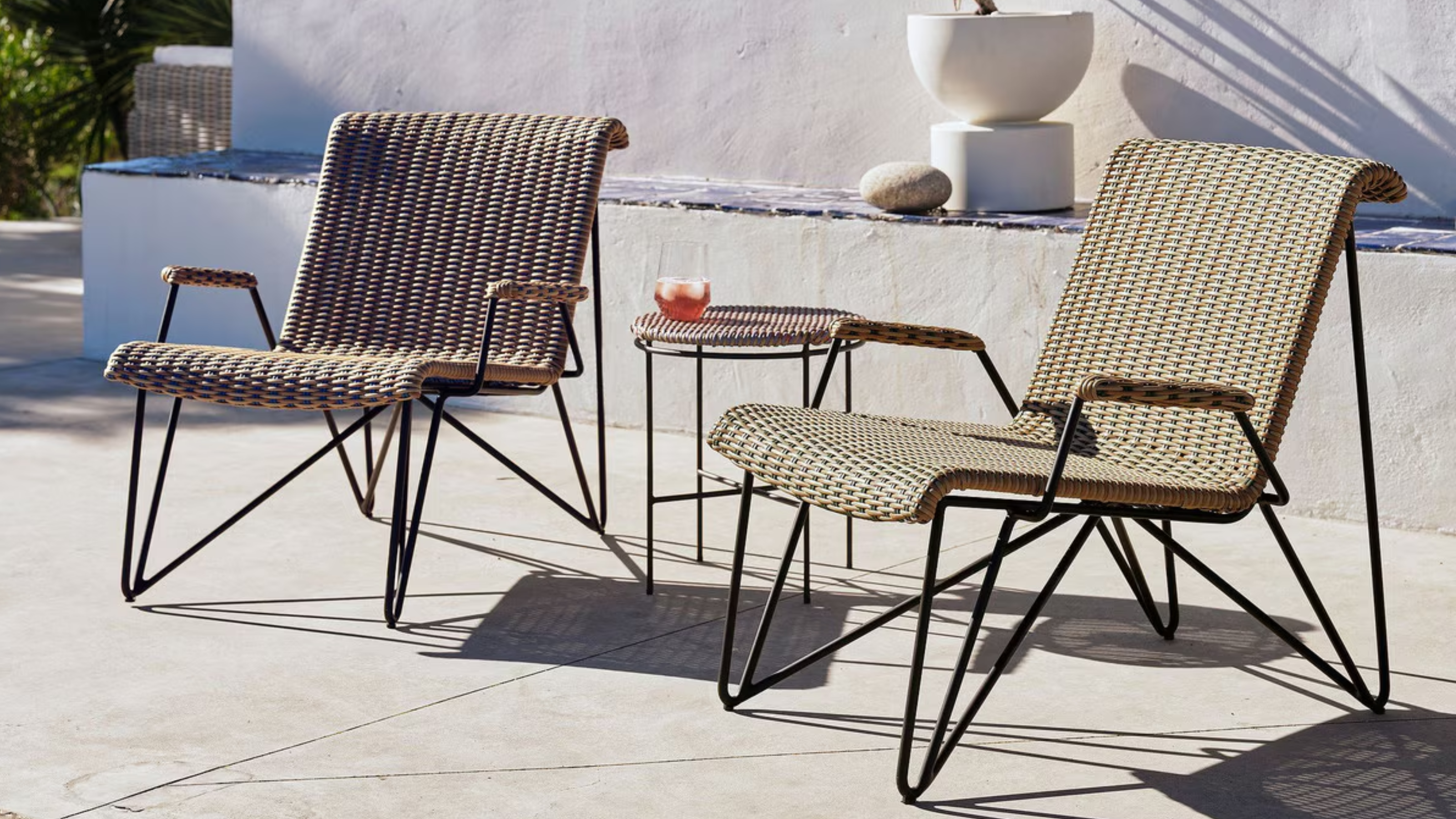 Two rattan garden chairs on a patio 
