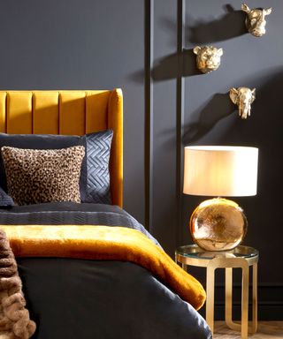 Gold and blue bed against dark blue matt wall