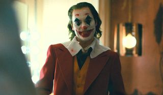 Joker smiling in the green room, after his makeup is finished