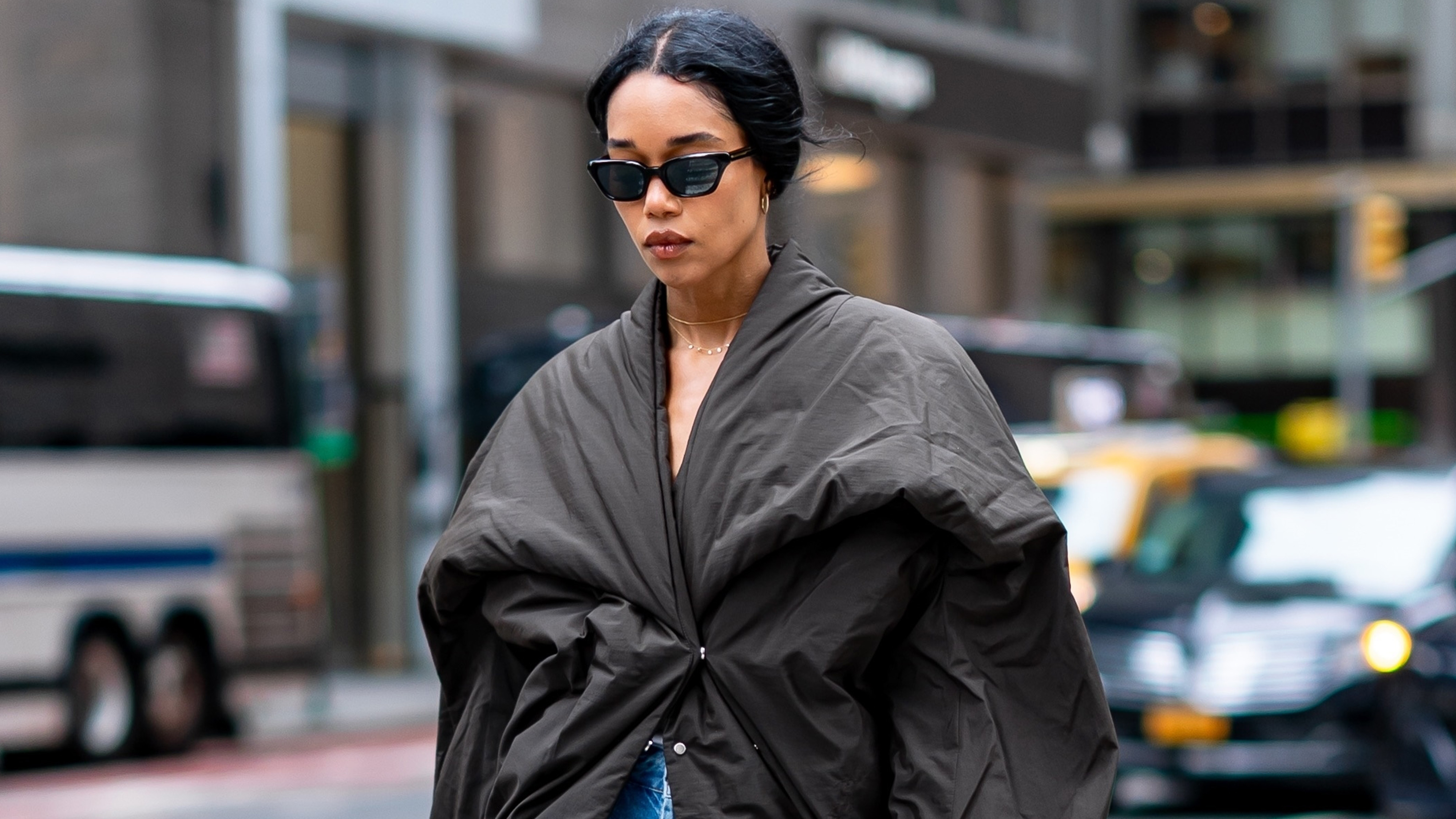 Laura Harrier wearing a puffer jacket, barrel-leg jeans, and burgundy patent leather heels in New York City. 