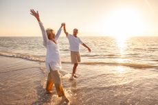Couple walking on the beach at sunset 