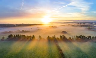 Colorful sunrise on foggy day over Tipperary mountains and fields.