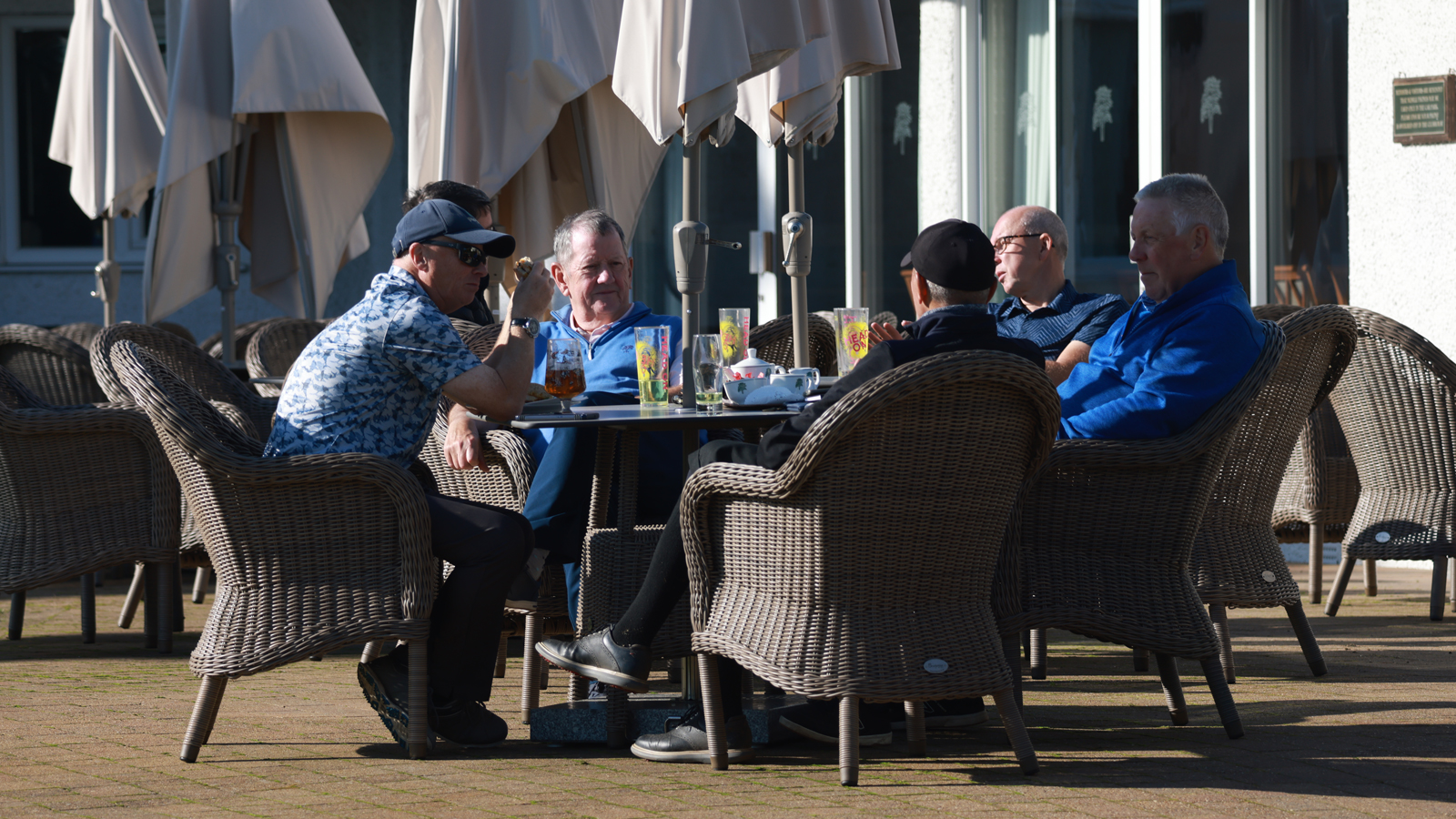 Golfers sitting round a table enjoying a drink