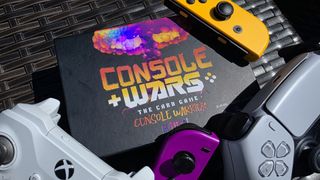 Console Wars Card Game box surrounded by game controllers