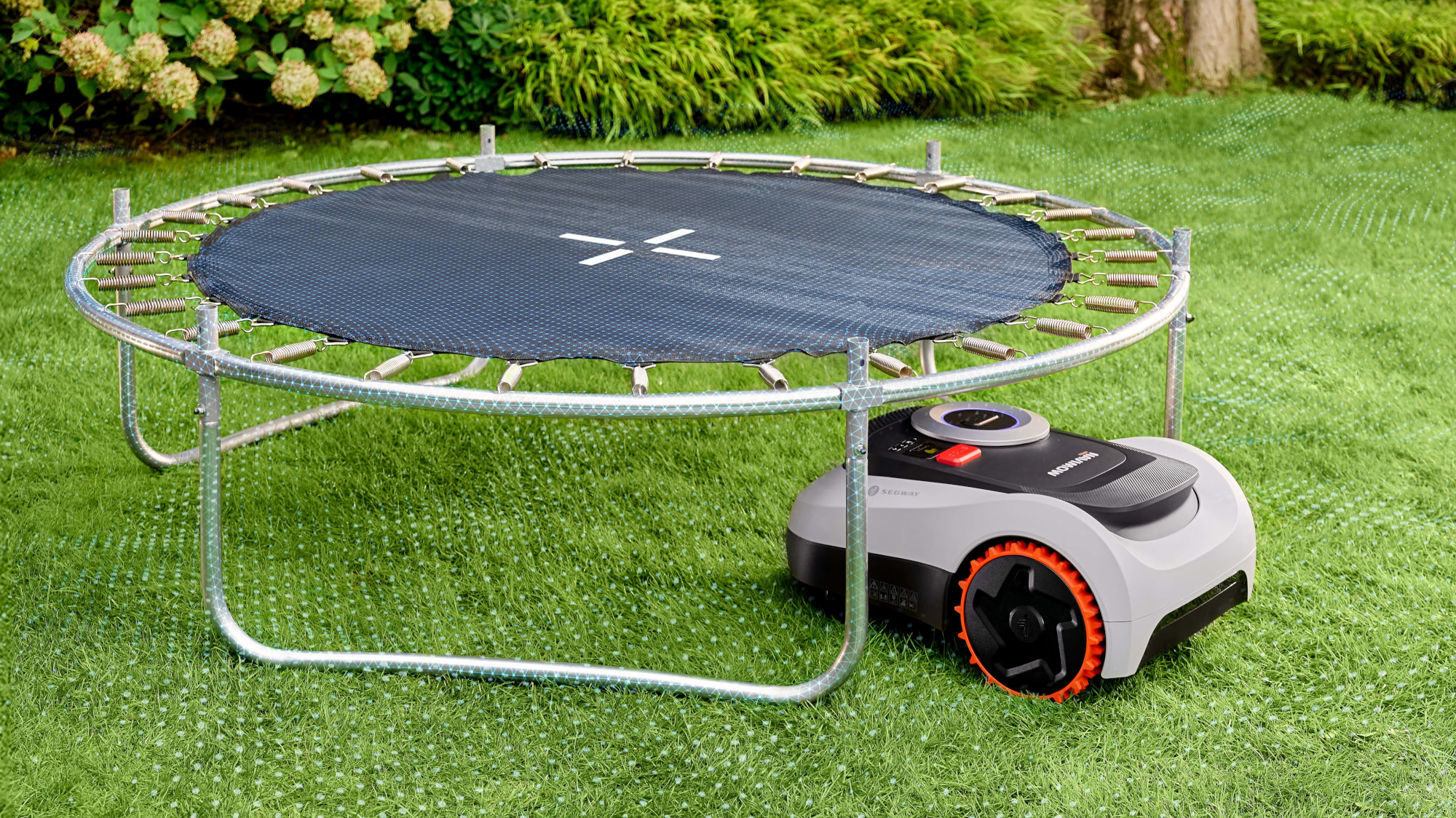 Segway Navimow i2 LiDAR cutting grass with trampoline nearby.
