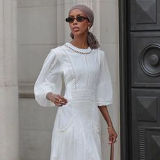 @basma_k wears a white maxi dress, tan ballet flats and a shoulder bag