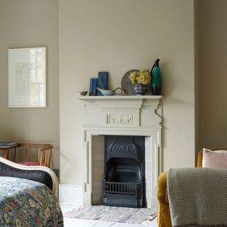 Off-white bedroom with a small white fireplace topped with vases