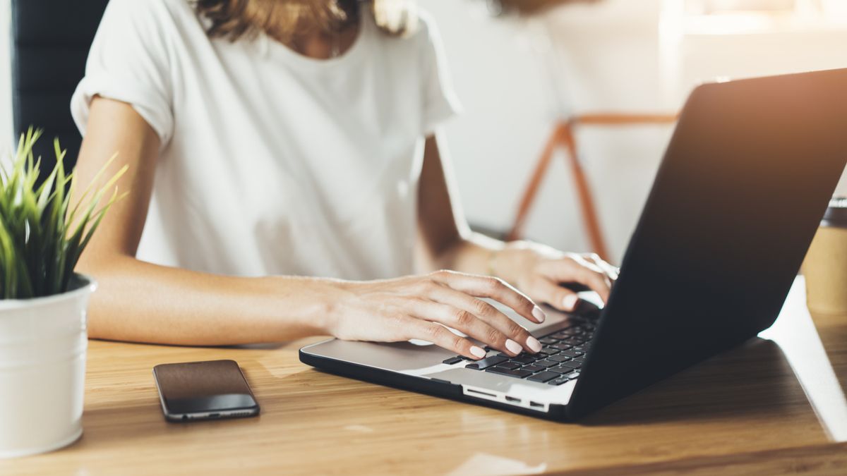 A person using a laptop at a desk