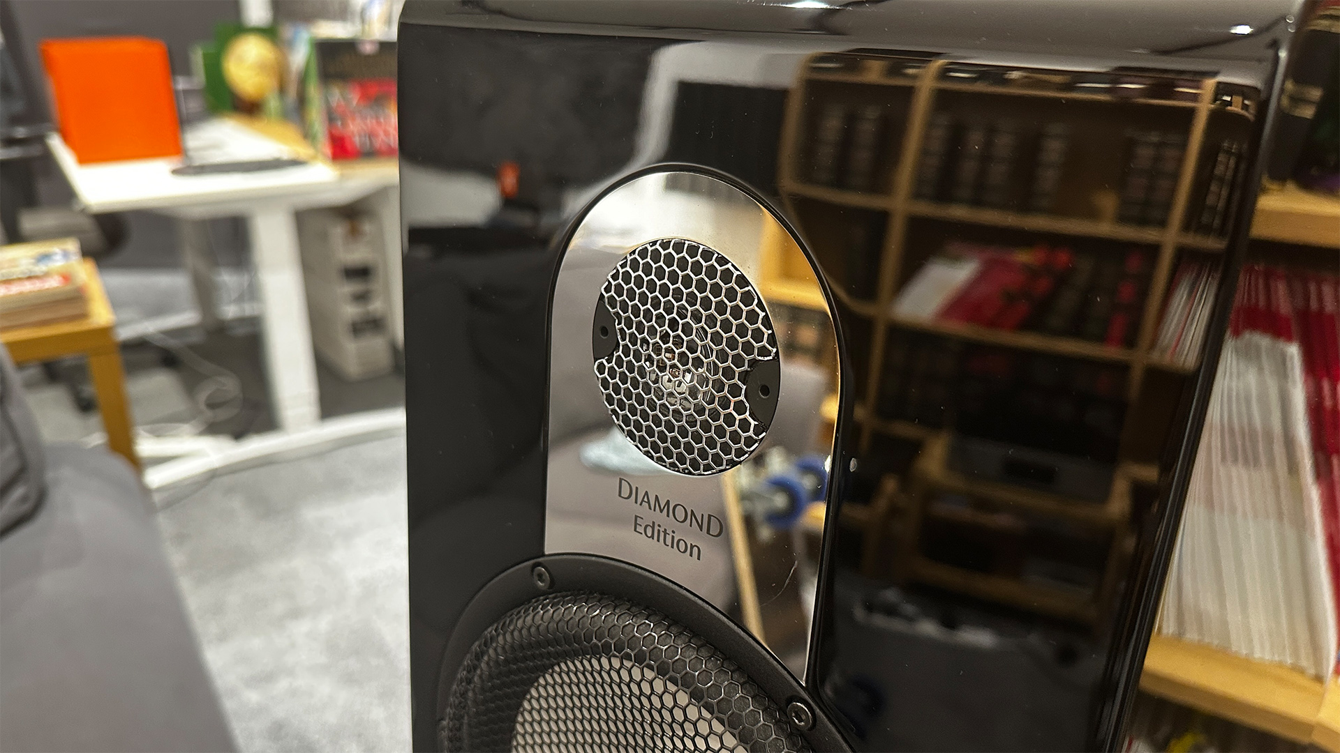 Marten Parker Duo Diamond Edition standmount speakers close up on tweeter, bookcase is reflected in glossy finish