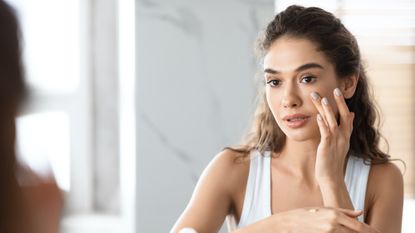 young woman applying skincare