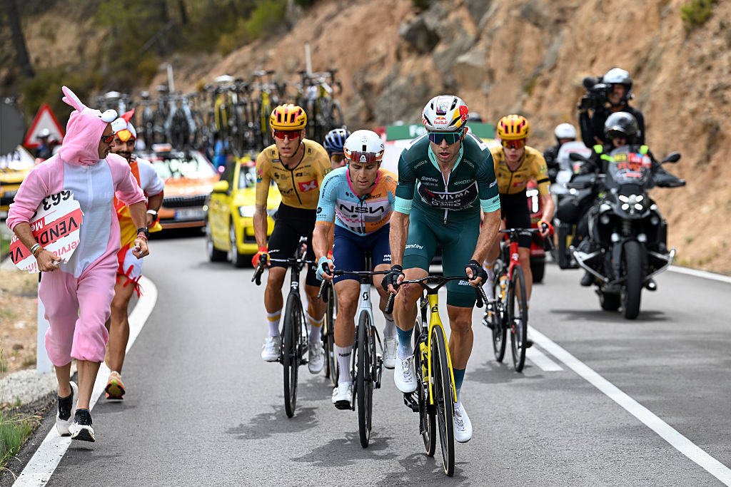 Wout Van Aert of Belgium and Team Visma | Lease a Bike - Green Points Jersey leads the breakaway while a fan in a pink bunny suit runs alongside cheering