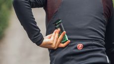 Female rider taking an energy bar out of her jersey pocket while riding