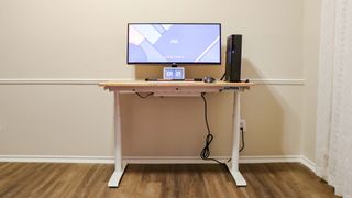 A standing desk with all of the cables organized in a cable management tray