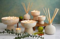 Blueme's scented candles and diffusers set against a sea-green background.