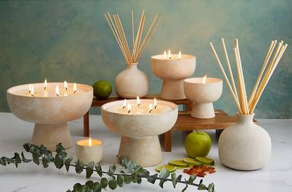 Blueme&#039;s scented candles and diffusers set against a sea-green background.