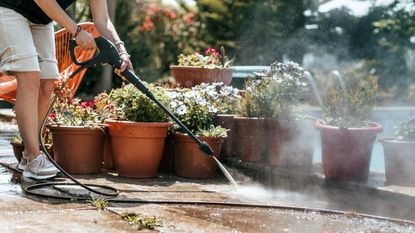 Person cleaning the poolside with high pressure water cleaning - for article on &#039;Is your pressure washer not making pressure?&#039;