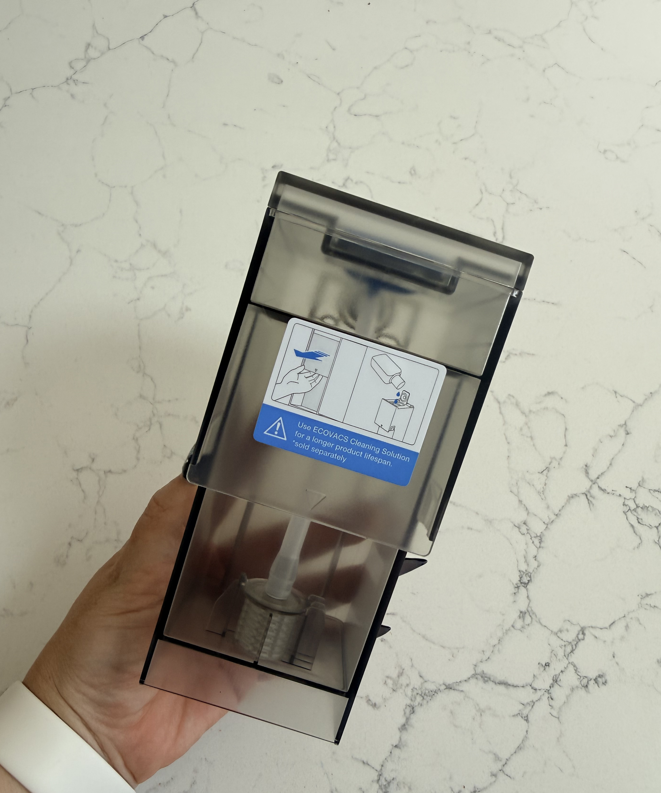 Cleaning solution cartridge for the Ecovacs Deebot T50 Pro Omni OMNI Station held in one hand