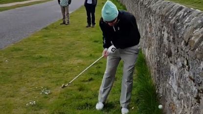 The player attempts a shot against the wall at the Road Hole, St Andrews