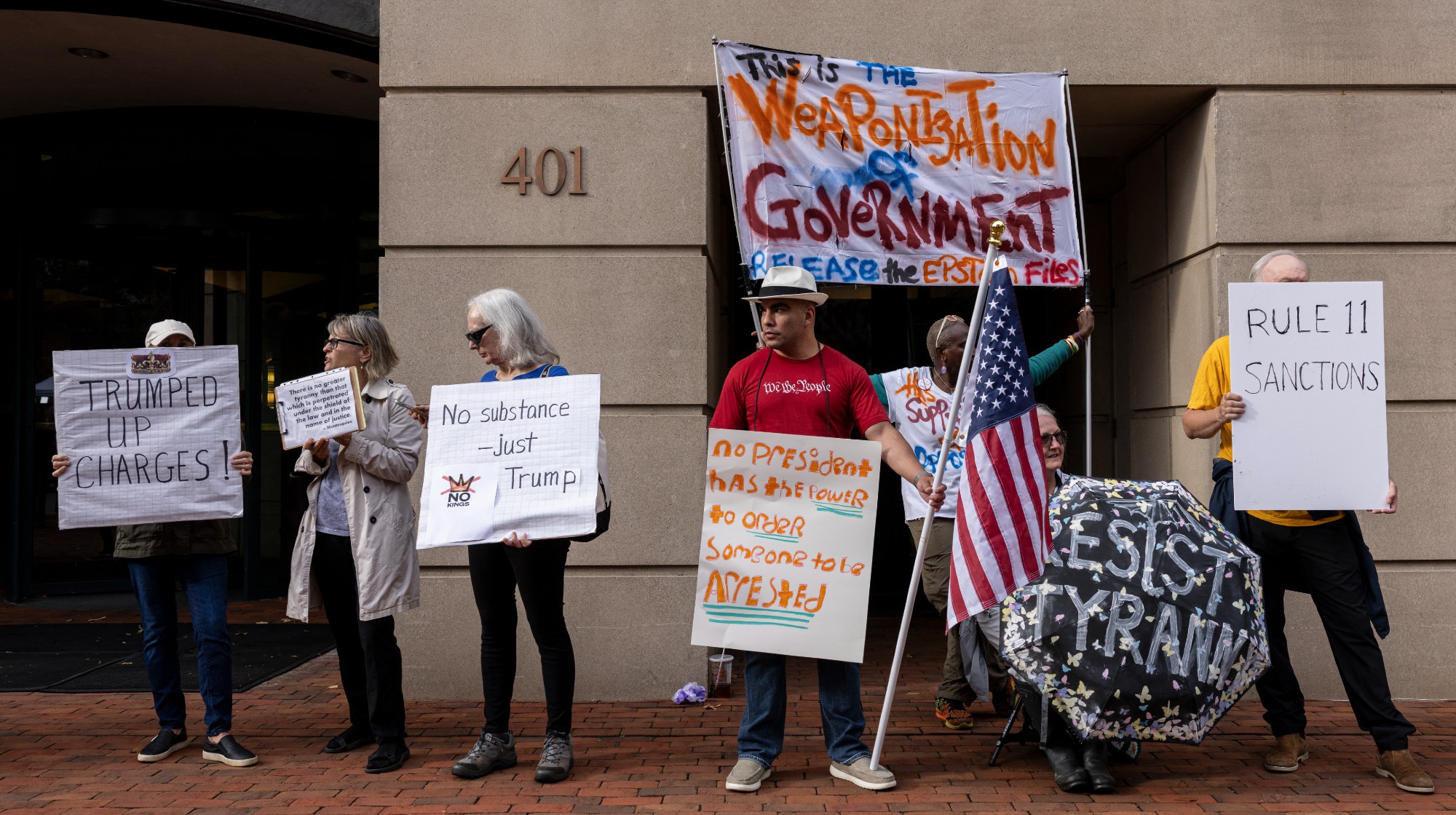 Activists protest outside the U.S. District Court for the Eastern District of Virginia during the arraignment of former FBI Director James Comey in Alexandria, Virginia, on October 8, 2025. Comey pleaded not guilty to charges of making a false statement and obstruction stemming from his 2020 congressional testimony. (Photo by Mehmet Eser / Middle East Images via AFP) (Photo by MEHMET ESER/Middle East Images/AFP via Getty Images)