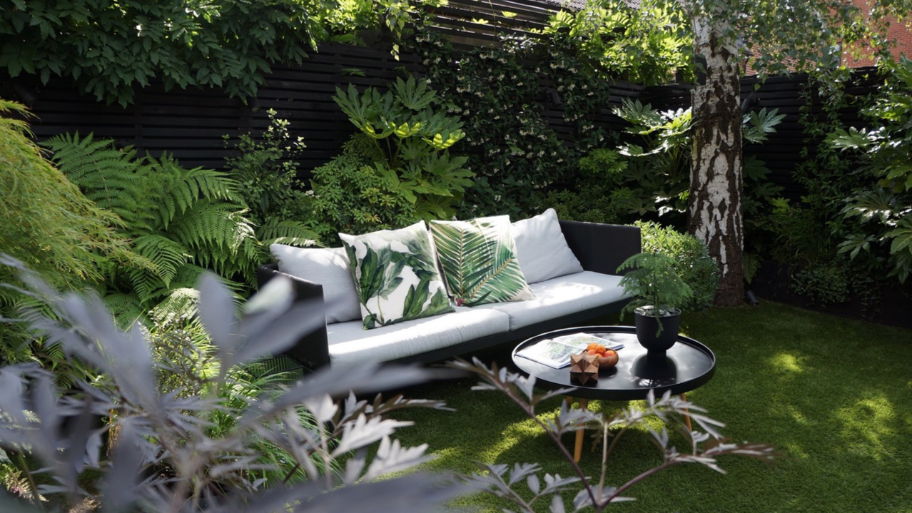 white outdoor sofa and coffee table in a secluded garden