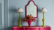 Blue wall, pint dresser and mirror, green lamps