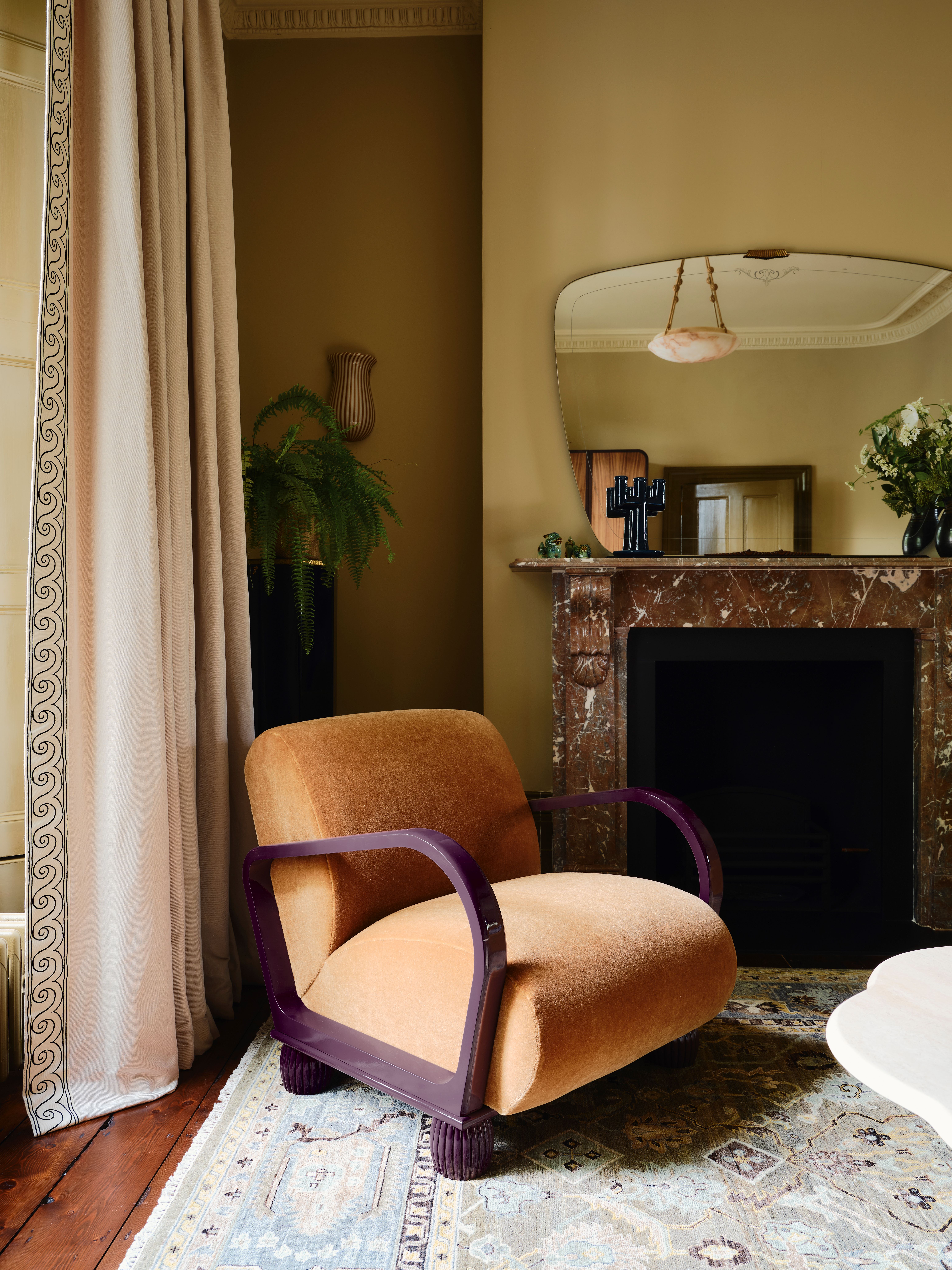Orange mohair armchair by marble fireplace