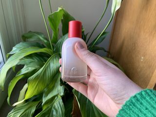 A close up of a person holding a Glossier You bottle