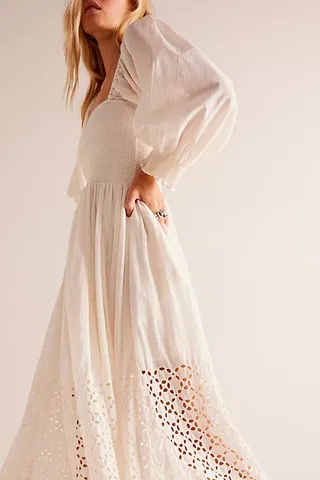 a model wears a white maxi dress with puffy sleeves