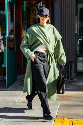 kendall jenner wearing polo hat and green poncho