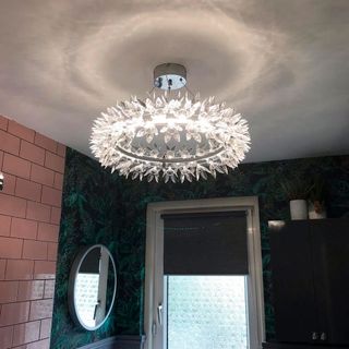Bathroom with chandelier and wallpaper on wall