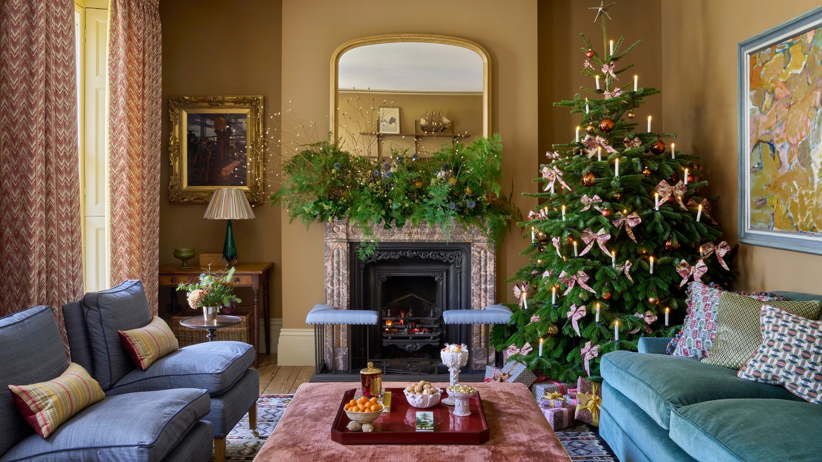 sitting room with blue sofas decorated for Christmas with large tree in the corner