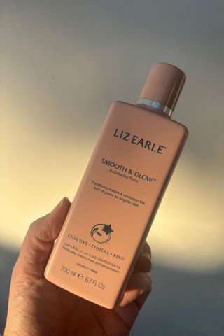 a hand holding liz earle smooth and glow tonic