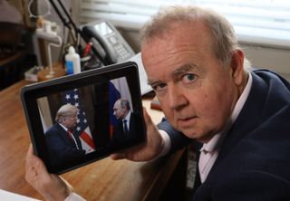 Ian Hislop with an ipad containing a picture of Donald Trump meeting Vladimir Putin