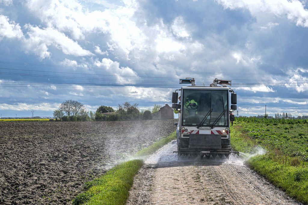 A road cleaning vehicle is seen cleaning a cobblestone section during the reconnaissance of the track ahead of this year's Paris-Roubaix cycling race, Friday 05 April 2024, around Roubaix, France. The Paris-Roubaix cycling races will take place this weekend, with the women riding on Saturday and the men on Sunday. BELGA PHOTO JONAS ROOSENS (Photo by JONAS ROOSENS / BELGA MAG / Belga via AFP)