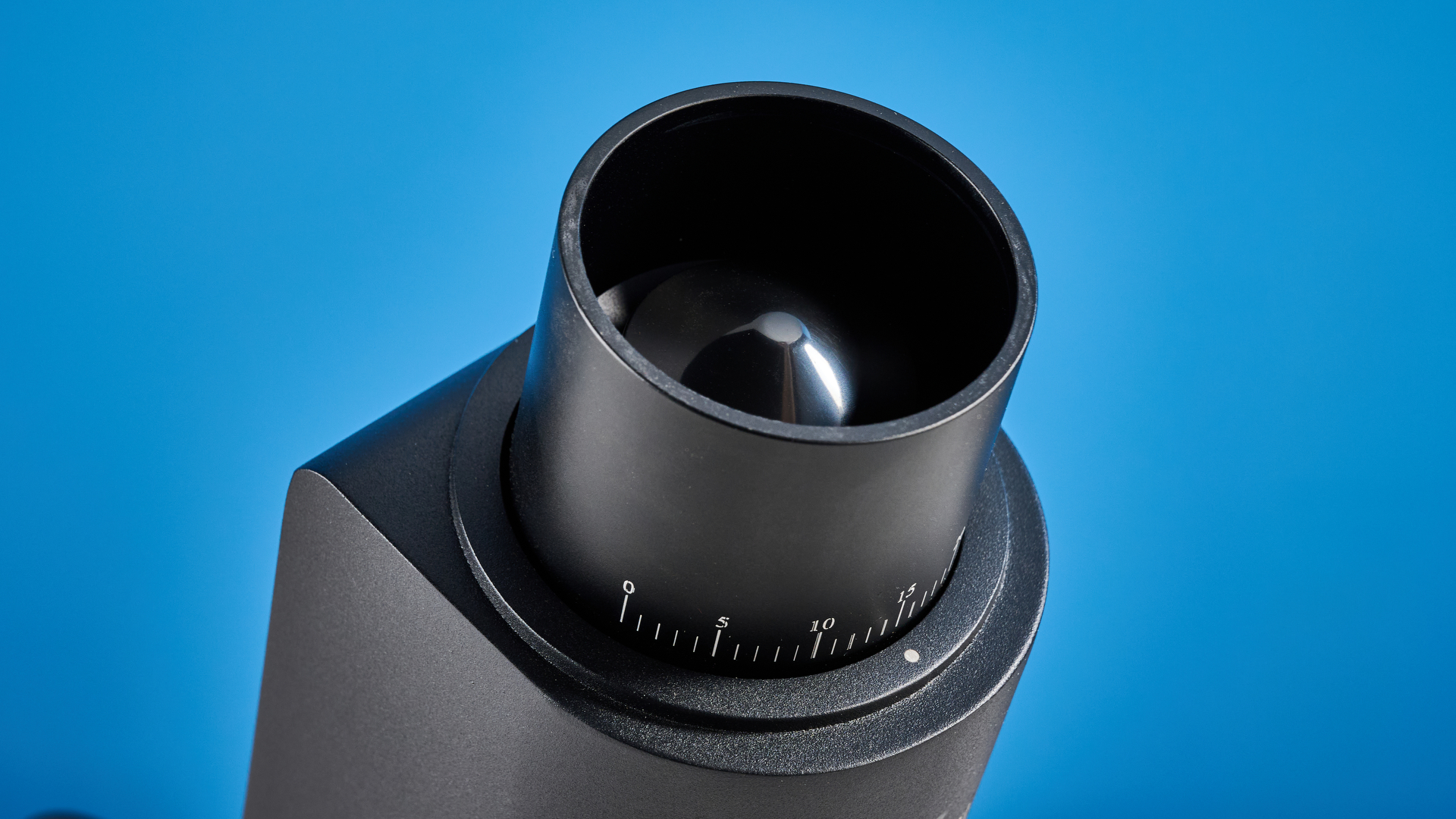 the wirsh geimori gu38 coffee grinder in black with a walnut hopper lid photographed against the blue tom's guide background