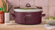 Crock Pot in burgundy on wooden counter
