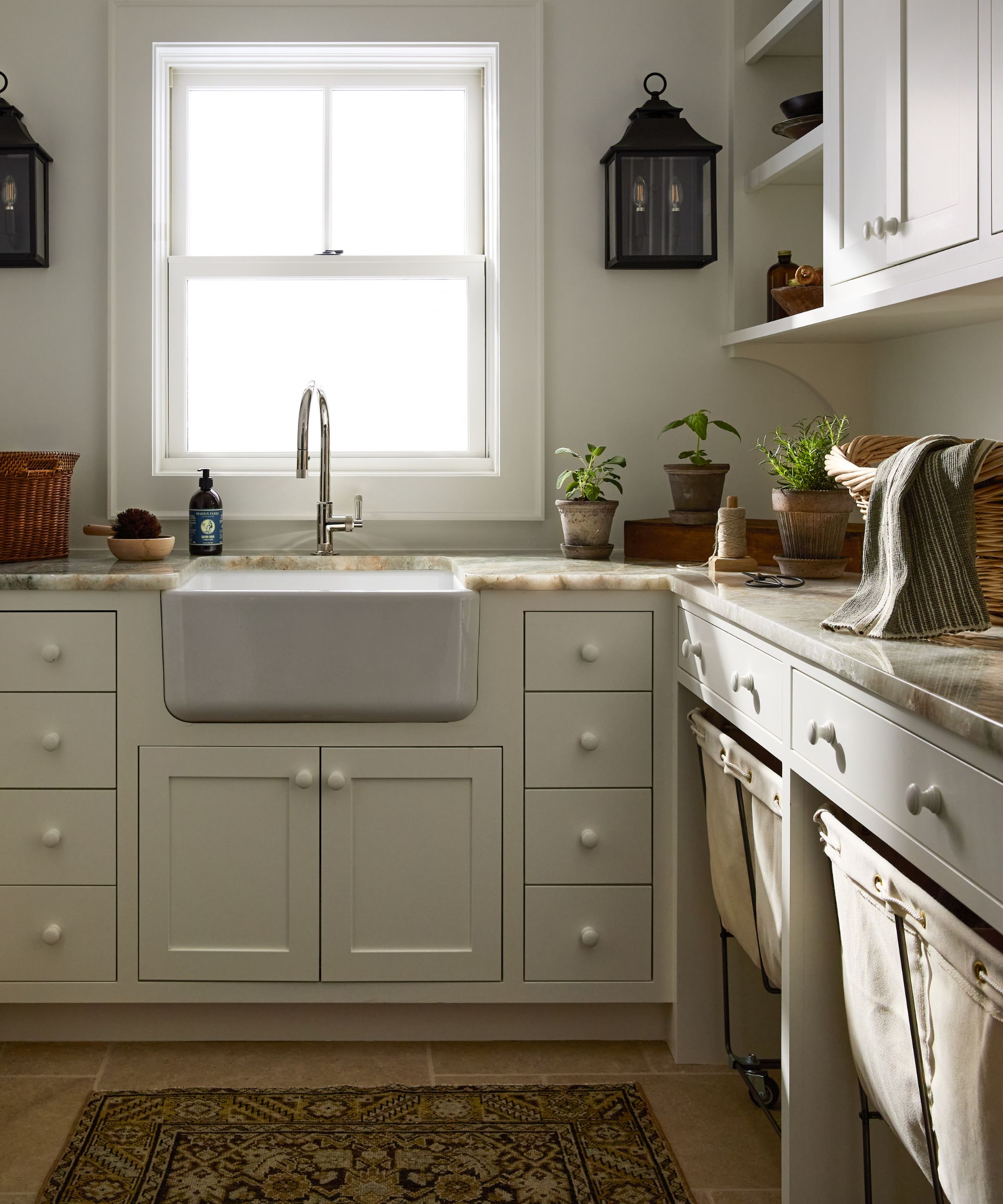 warm white utility laundry kitchen back kitchen space with a farmhouse sink and canvas laundry basket storage