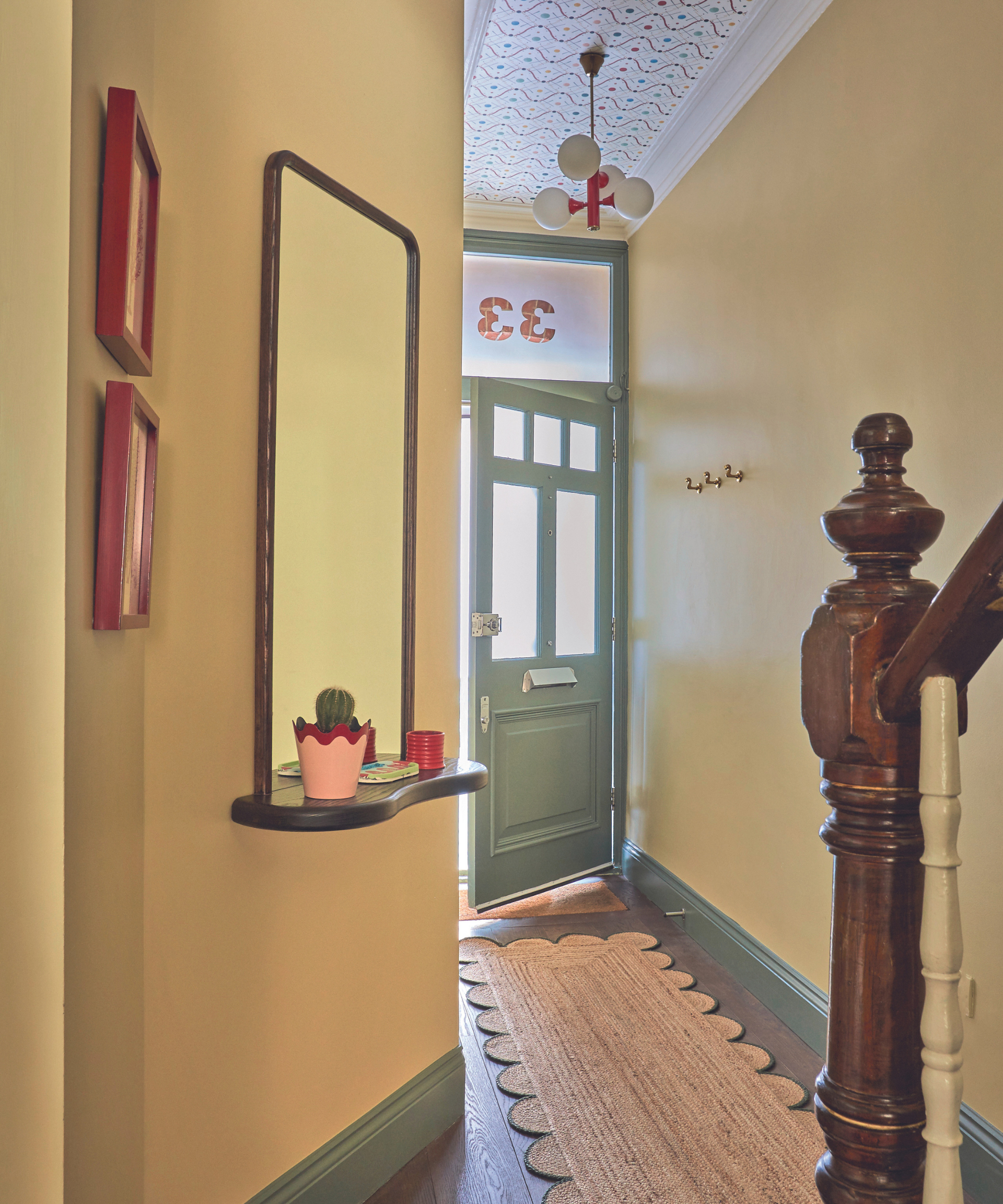 yellow hallway with green accents and long scalloped segrass runner and mirror on wall with ledge