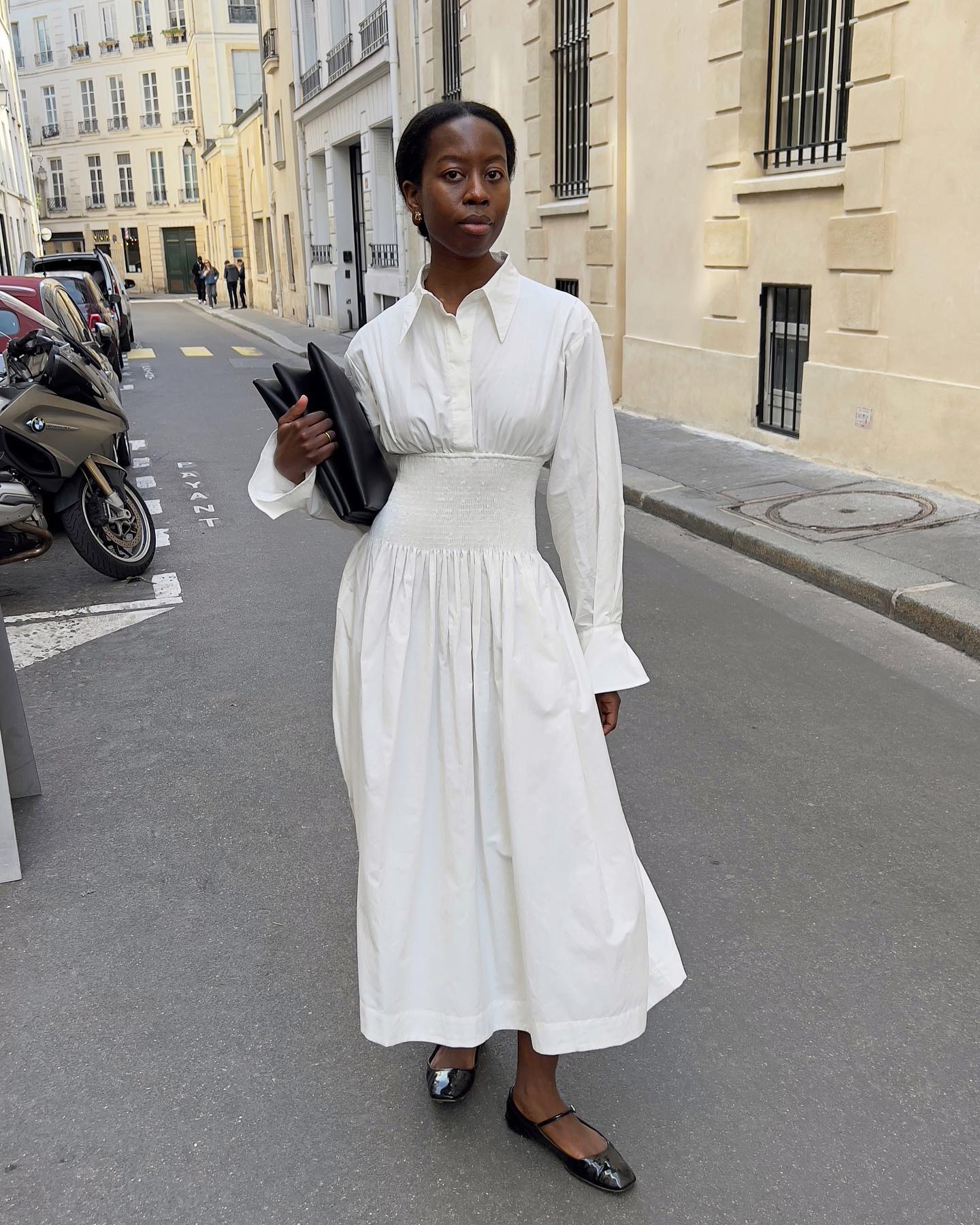 Woman wearing a white shirtdress and Mary Janes