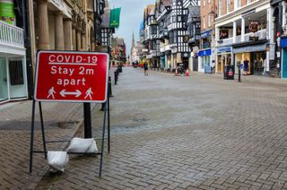 A sign in Chester City, UK asking people to socially distance.