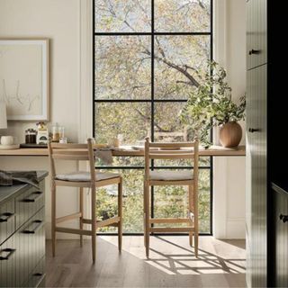 Two wooden bar chairs against a black framed window from McGee & Co.