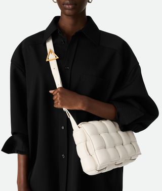 model holding white Bottega Veneta padded cassette bag