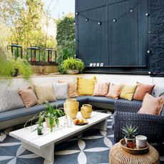 A living wall, framework with plants, vertical planting, above a sunken seating area in an urban garden