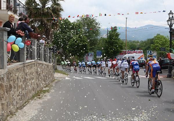 Fans toss confetti on the riders as they pass through town.