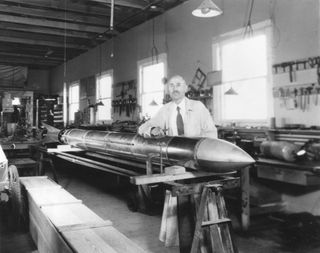 Dr. Robert Goddard with a rocket in his workshop at Roswell, New Mexico, in October 1935.