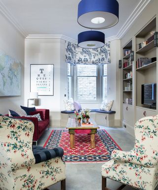 Blue ceiling lights as a small living room lighting idea with floral armchairs.