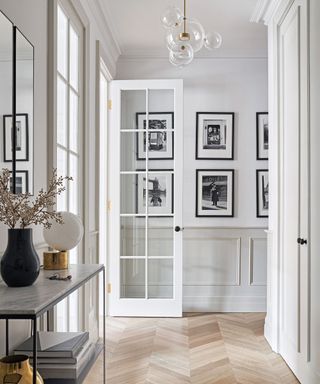 minimalist hallway with black and white photographs and parquet flooring