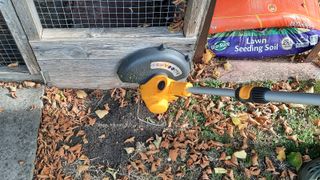 Stiga GT 100e battery lawn trimmer up against a wooden edge