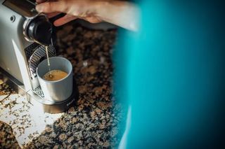 An espresso cup and espresso machine