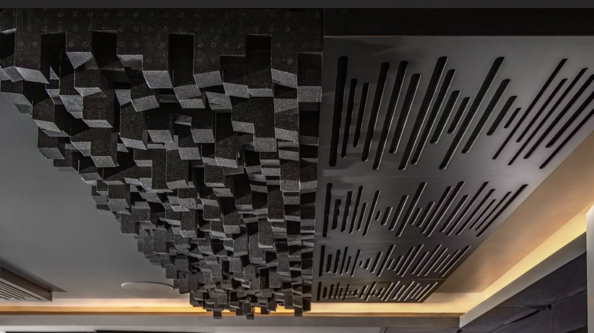 A photo of a custom-installed home cinema room featuring a 4K projector, theatre seating and clever acoustic treatment